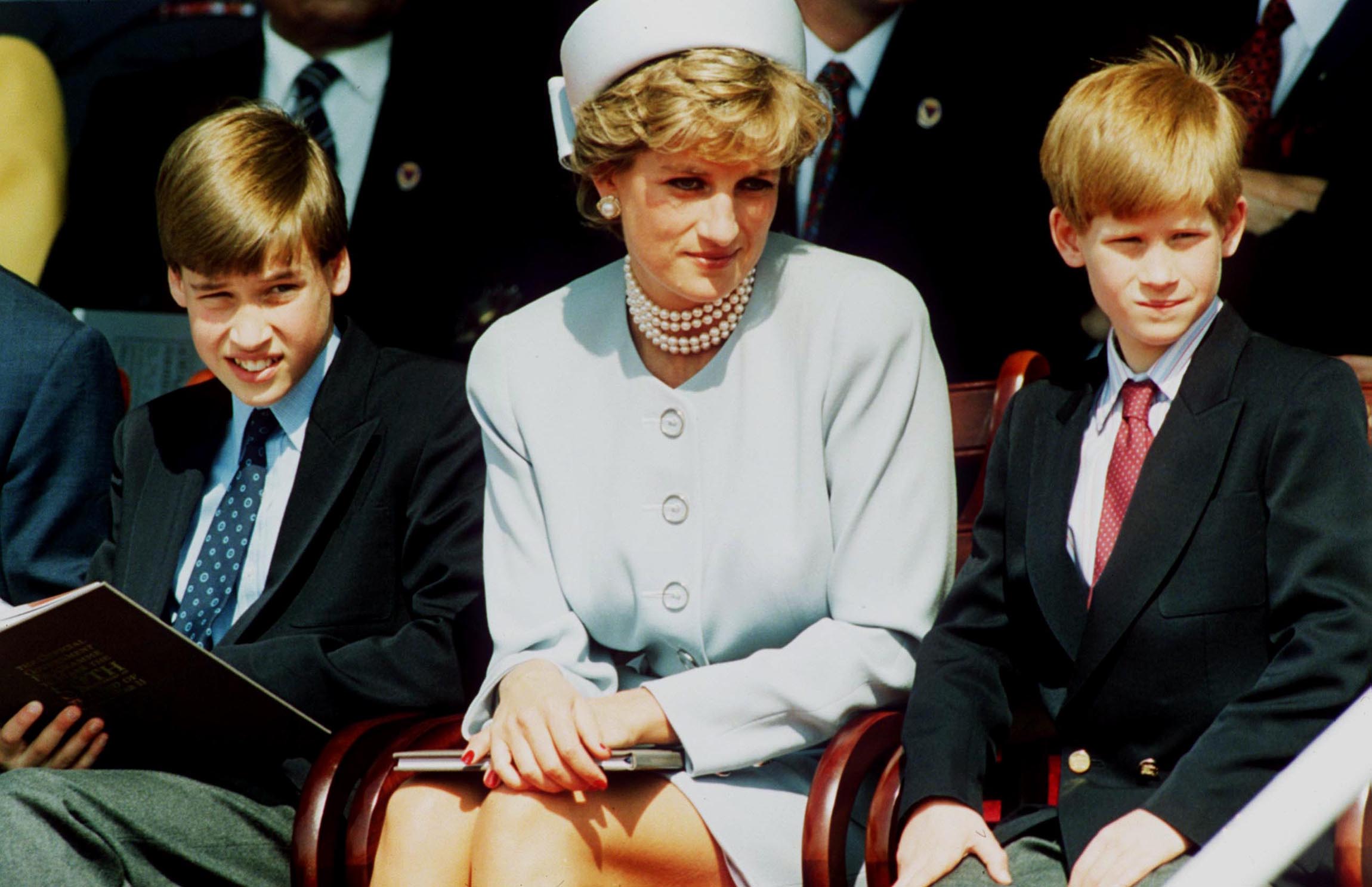 Prince William, Princess Diana, and Prince Harry sit together.