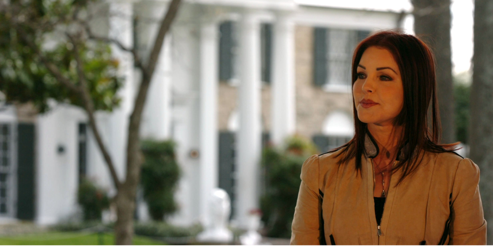 Priscilla Presley poses in front of Graceland in Memphis, TN.