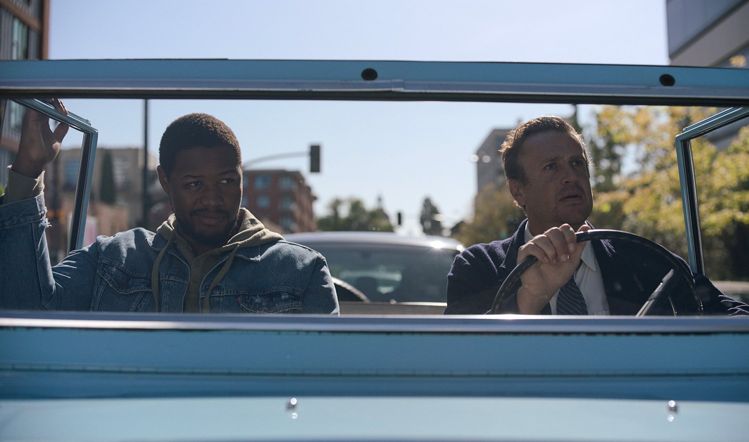 Luke Tennie as Sean and Jason Segel as Jimmy riding in a blue car in Shrinking.