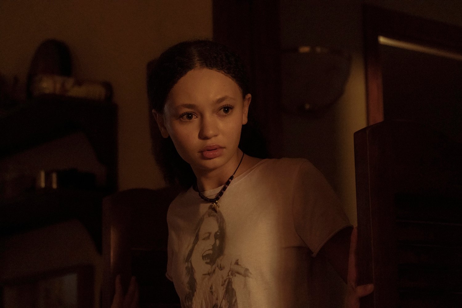 Nico Parker as Sarah looking worried in a dark room in The Last of Us