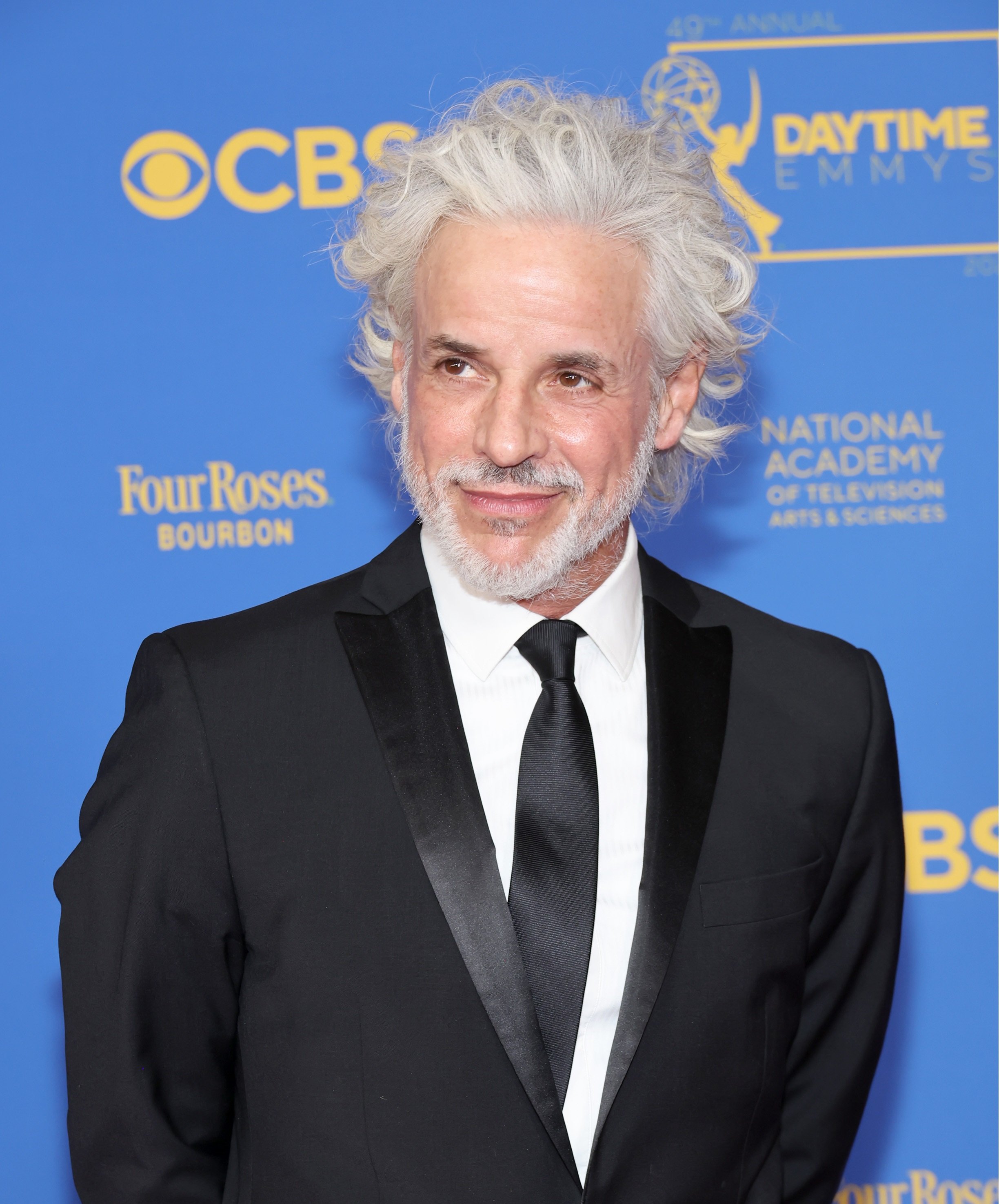 'The Young and the Restless' star Christian LeBlanc dressed in a tuxedo; poses on the red carpet of the 2022 Daytime Emmys.