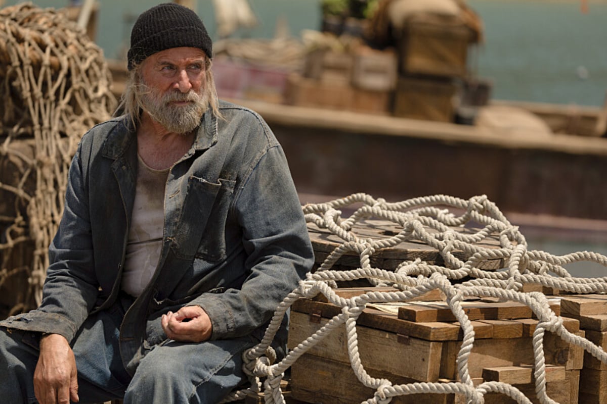 Peter Stormare as Lucca the tugboat captain in 1923. Lucca wears jeans, a denim, and a black stocking cap.