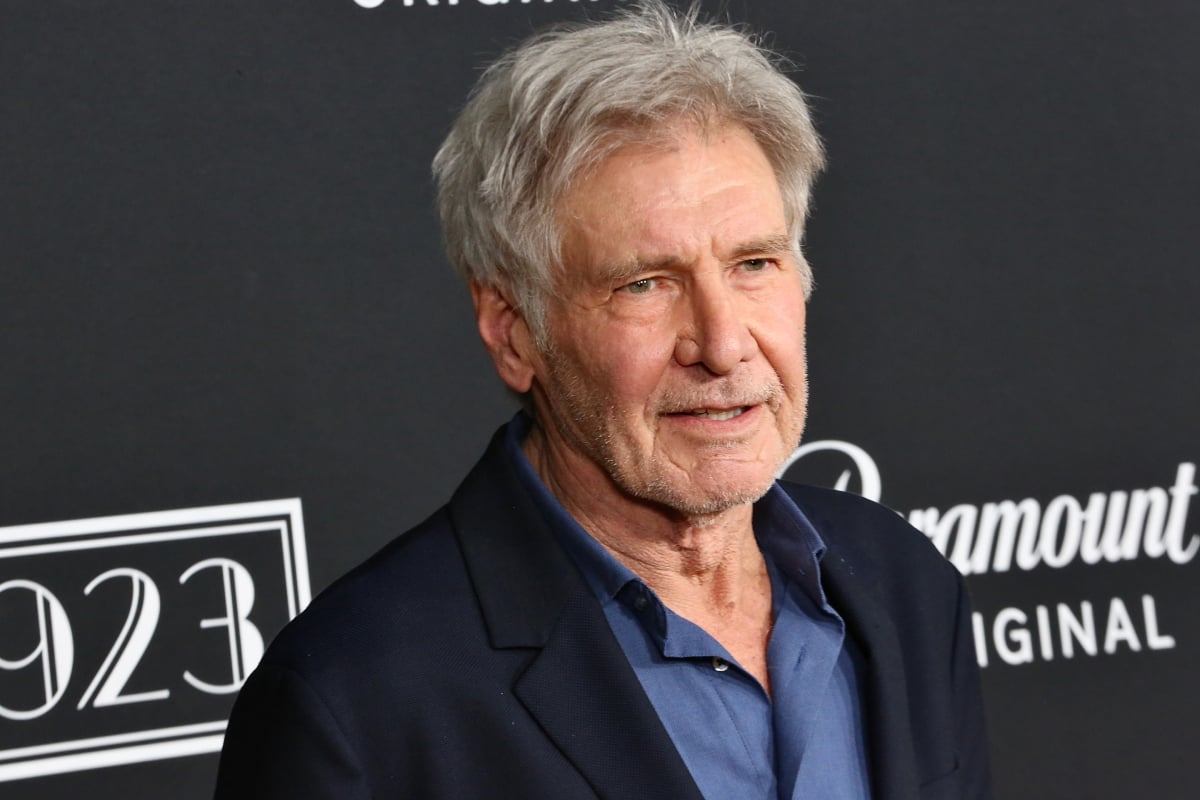 Harrison Ford attends the Los Angeles premiere of 1923 wearing a navy blazer and collared blue shirt.