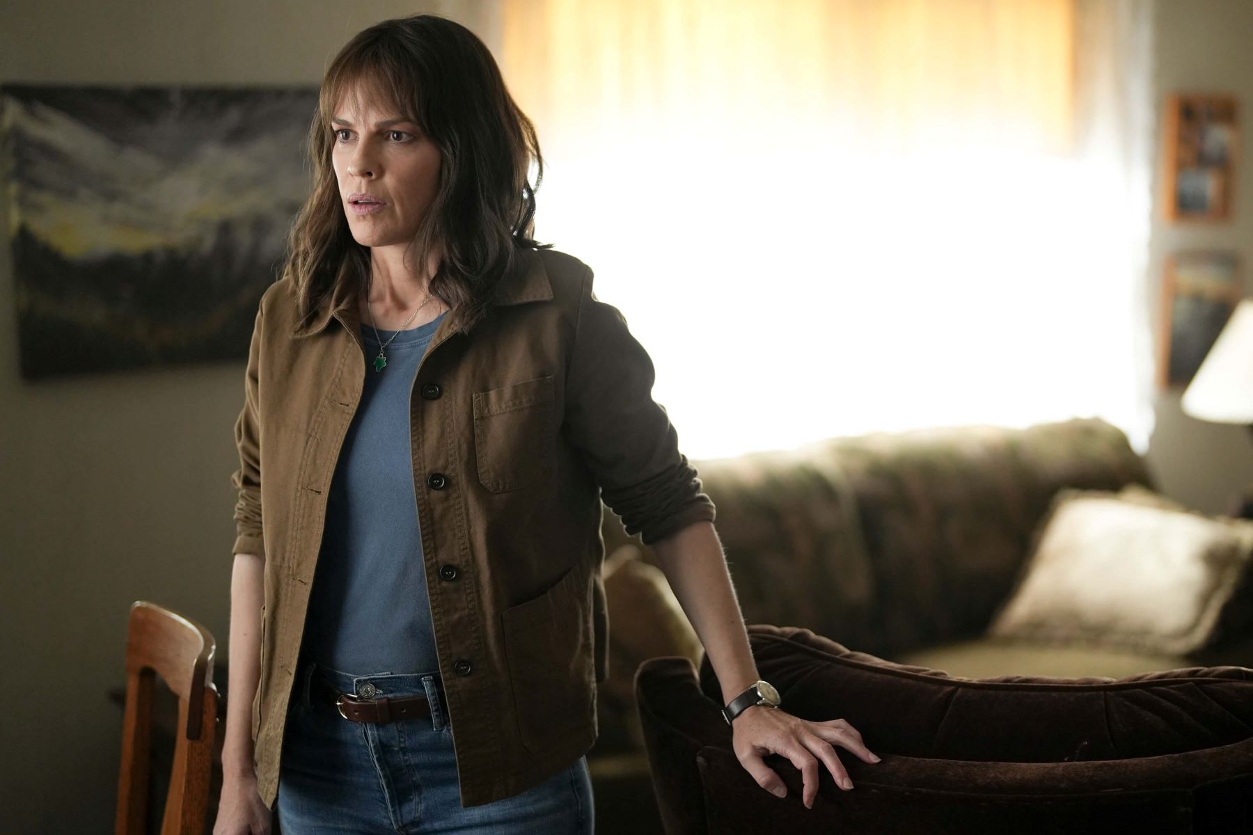 Hilary Swank, in character as Eileen Fitzgerald in 'Alaska Daily,' which has yet to be renewed for season 2, wears a brown jacket over a blue shirt and jeans.
