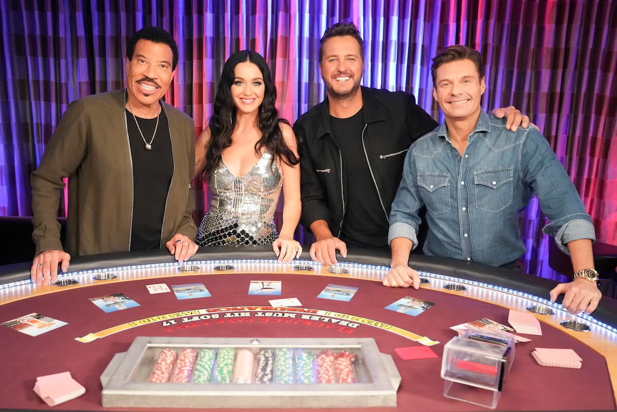 American Idol judges Lionel Richie, Katy Perry, Luke Bryan, and host Ryan Seacrest pose together at a gambling table.