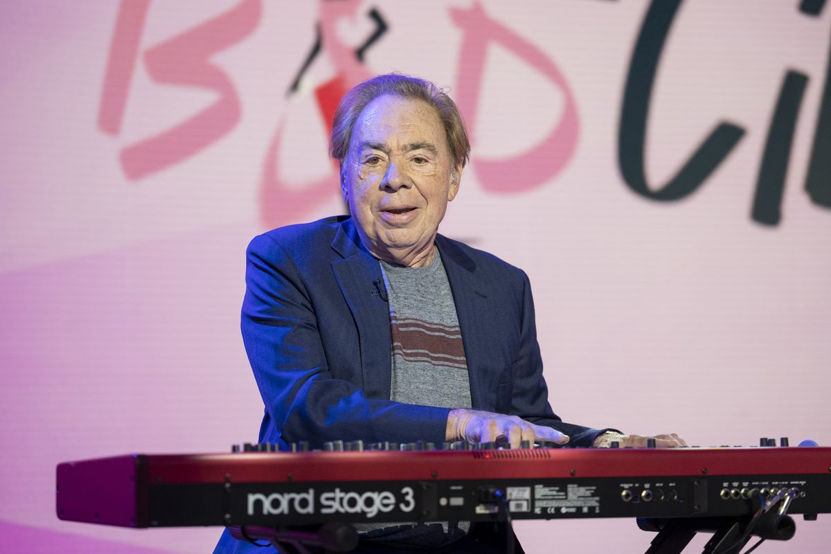 Andrew Lloyd Webber playing a biano in front of a "Bad Cinderella" backdrop.