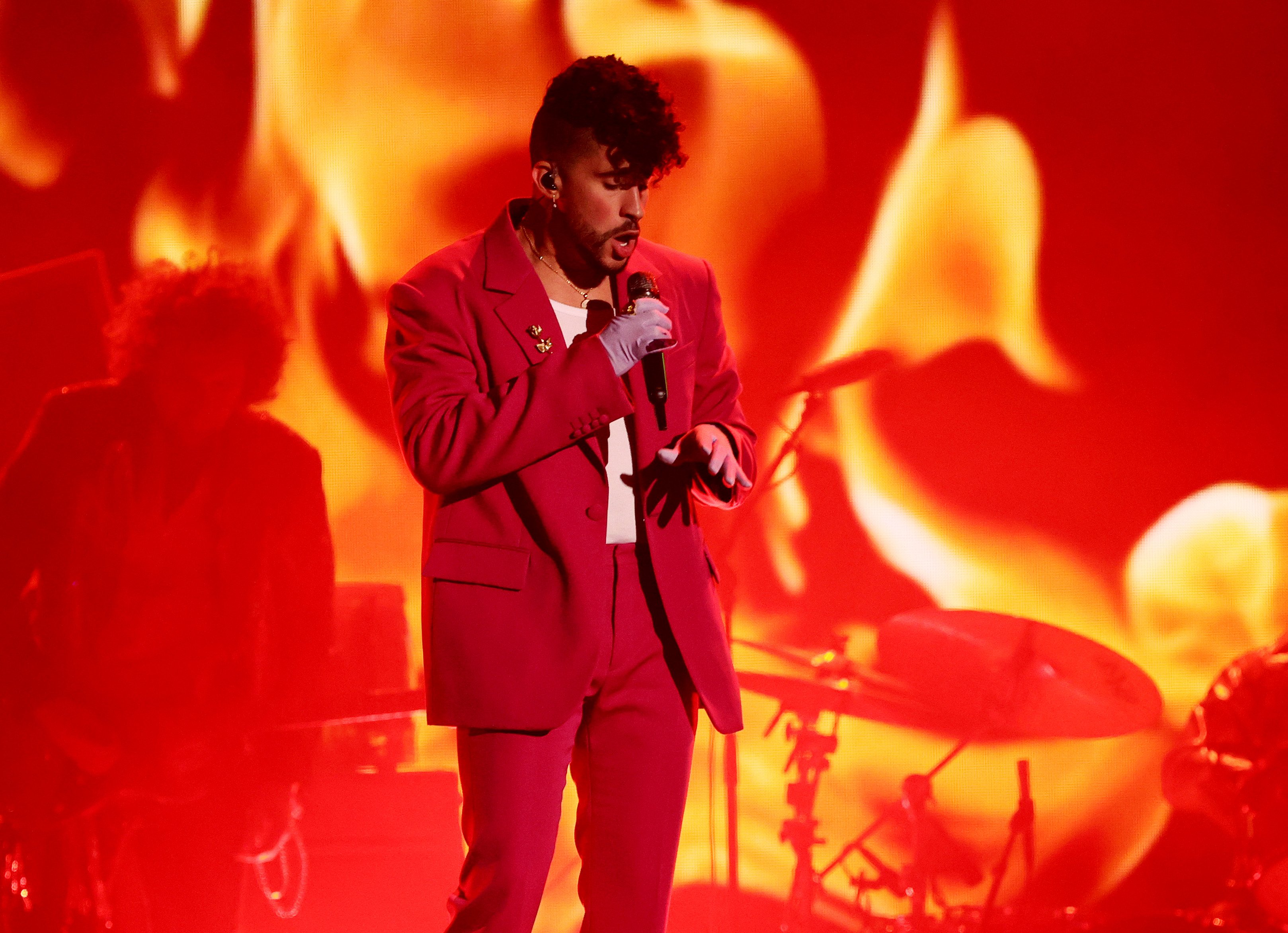 Bad Bunny performs in a red suit at the Latin Grammys.