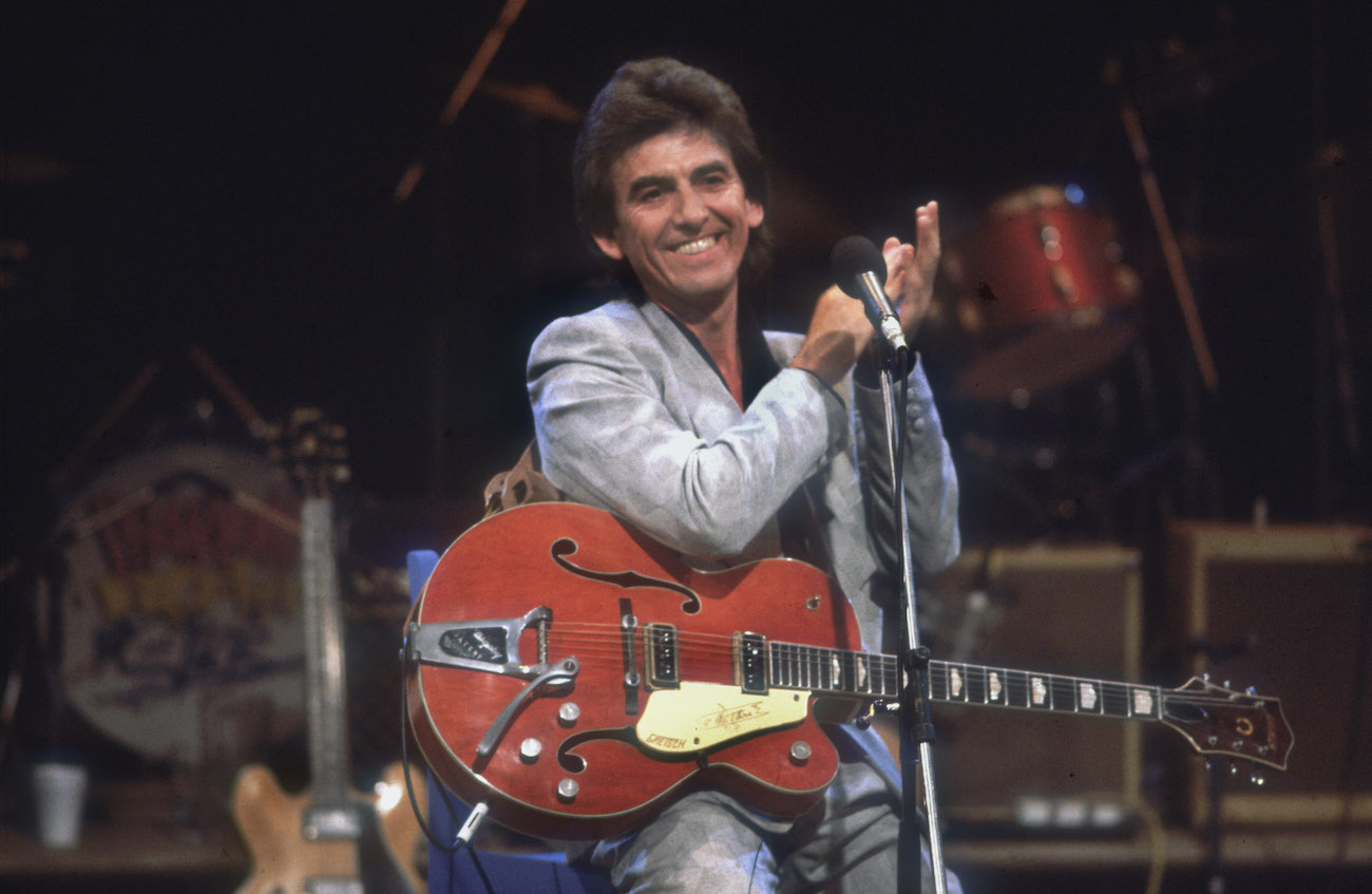 George Harrison of The Beatles performing in a silver suit at Ferry Aid in 1987.