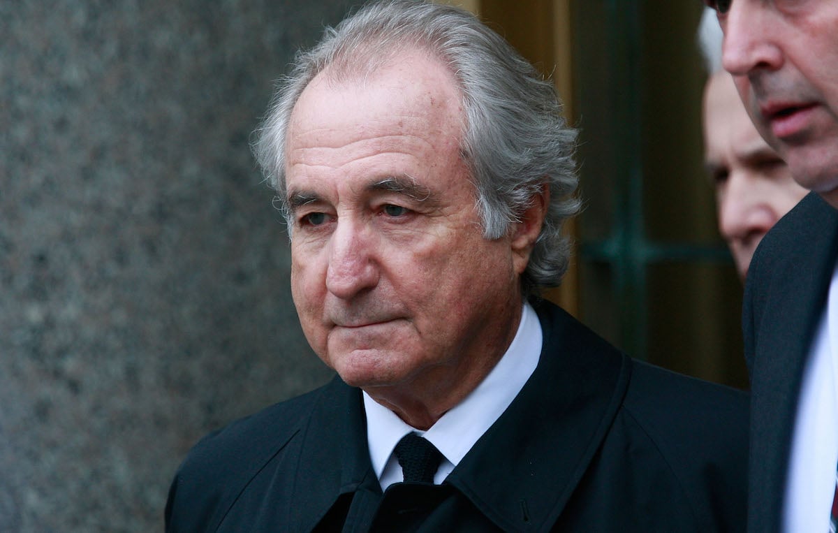 Bernie Madoff looks downward as he leaves a court building.