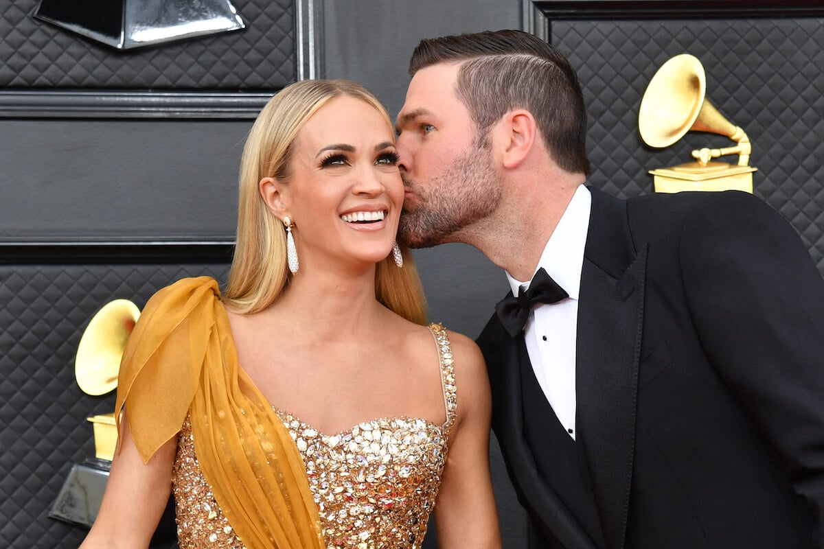 Mike Fisher kisses wife Carrie Underwood on the cheek at an event.