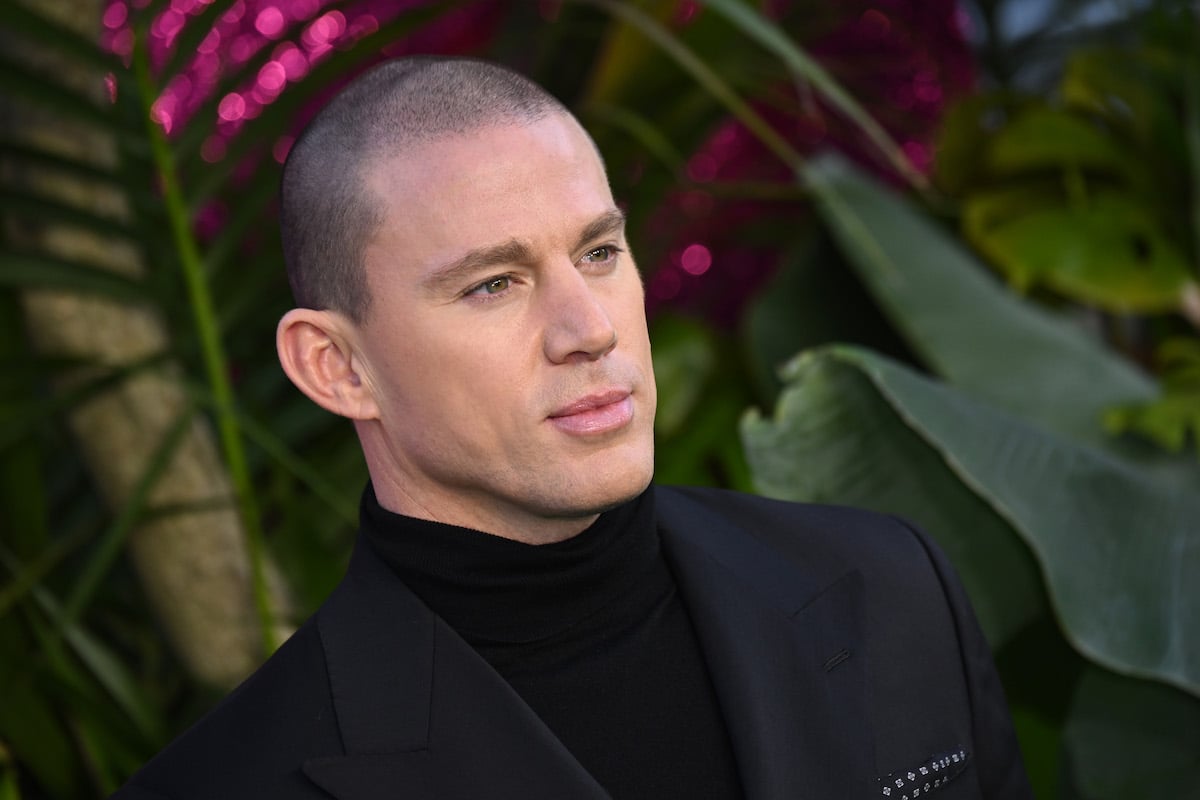 Chaning Tatum poses for pictures in front of a plant.