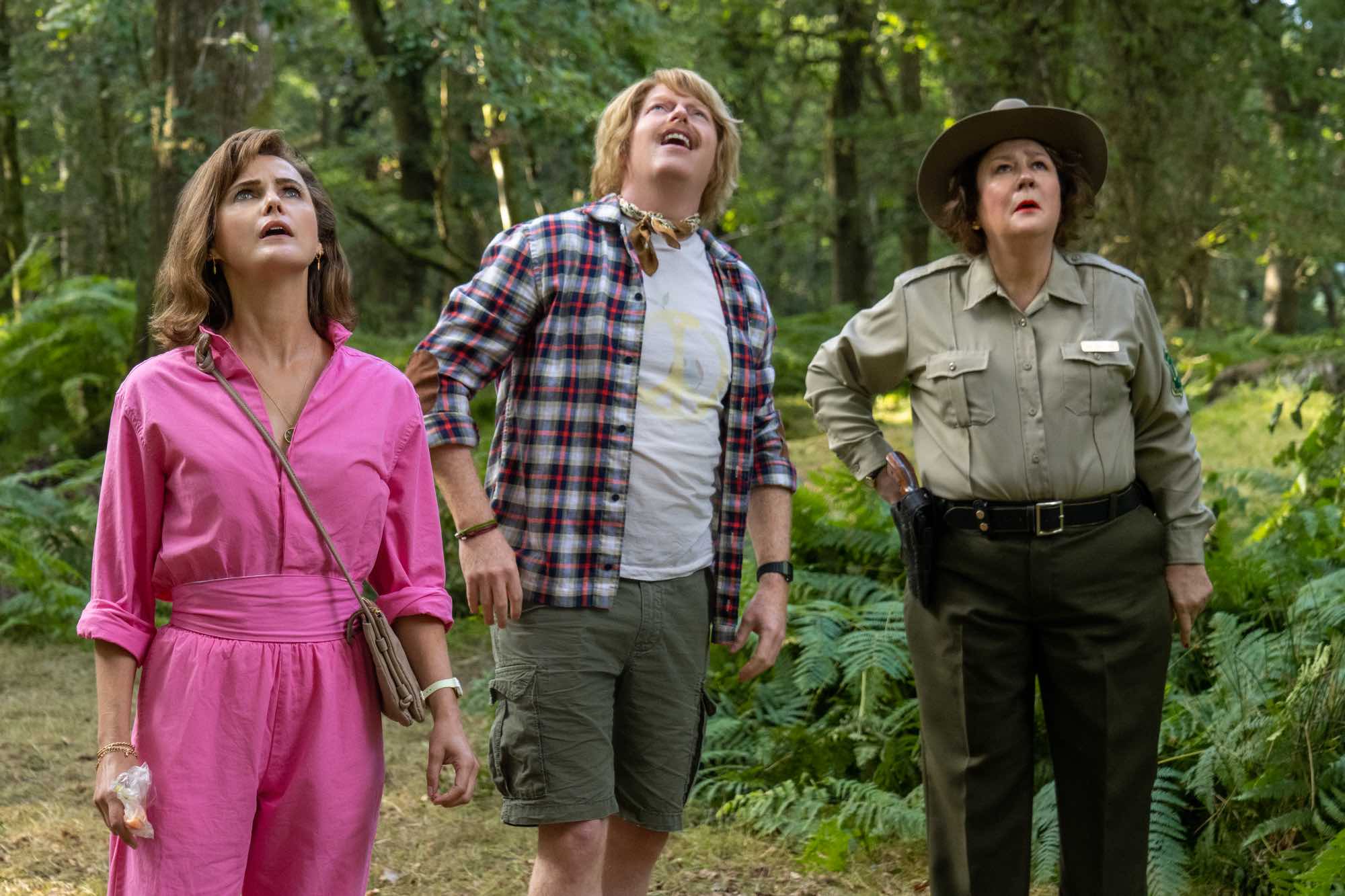 'Cocaine Bear' Keri Russell as Sari, Jesse Tyler Ferguson as Peter, and Margo Martindale as Ranger Liz looking worried looking up into a tree