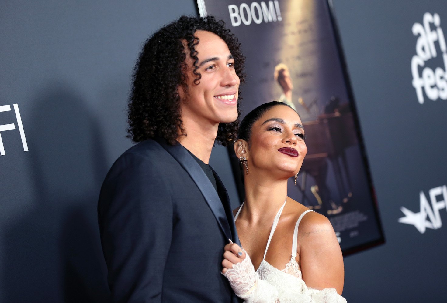 Cole Tucker and Vanessa Hudgens standing together and smiling at an event