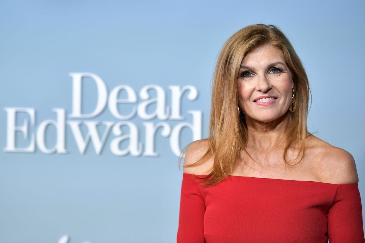 Connie Britton smiles for cameras in a red dress at the premiere for Apple's Dear Edward
