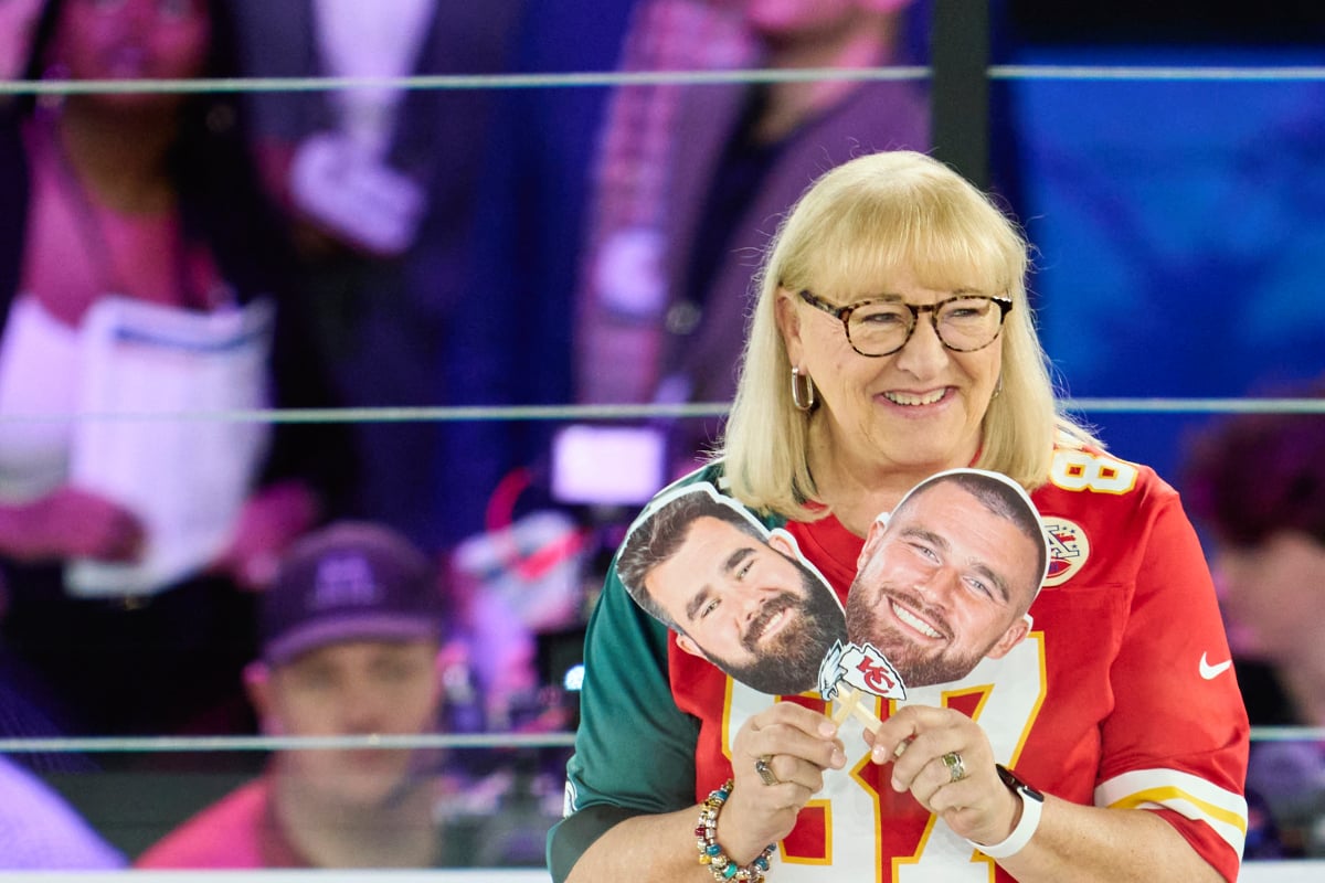 Donna Kelce holds up photos of her sons, Jason Kelce #62 of the Philadelphia Eagles and Travis Kelce #87 of the Kansas City Chiefs at Footprint Center on February 6, 2023 in Phoenix, Arizona