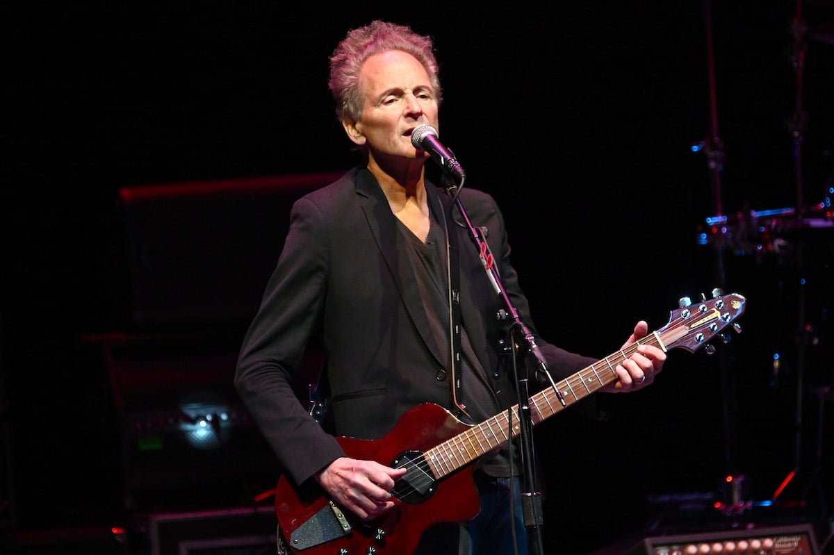 Lindsey Buckingham sings and plays guitar on stage.