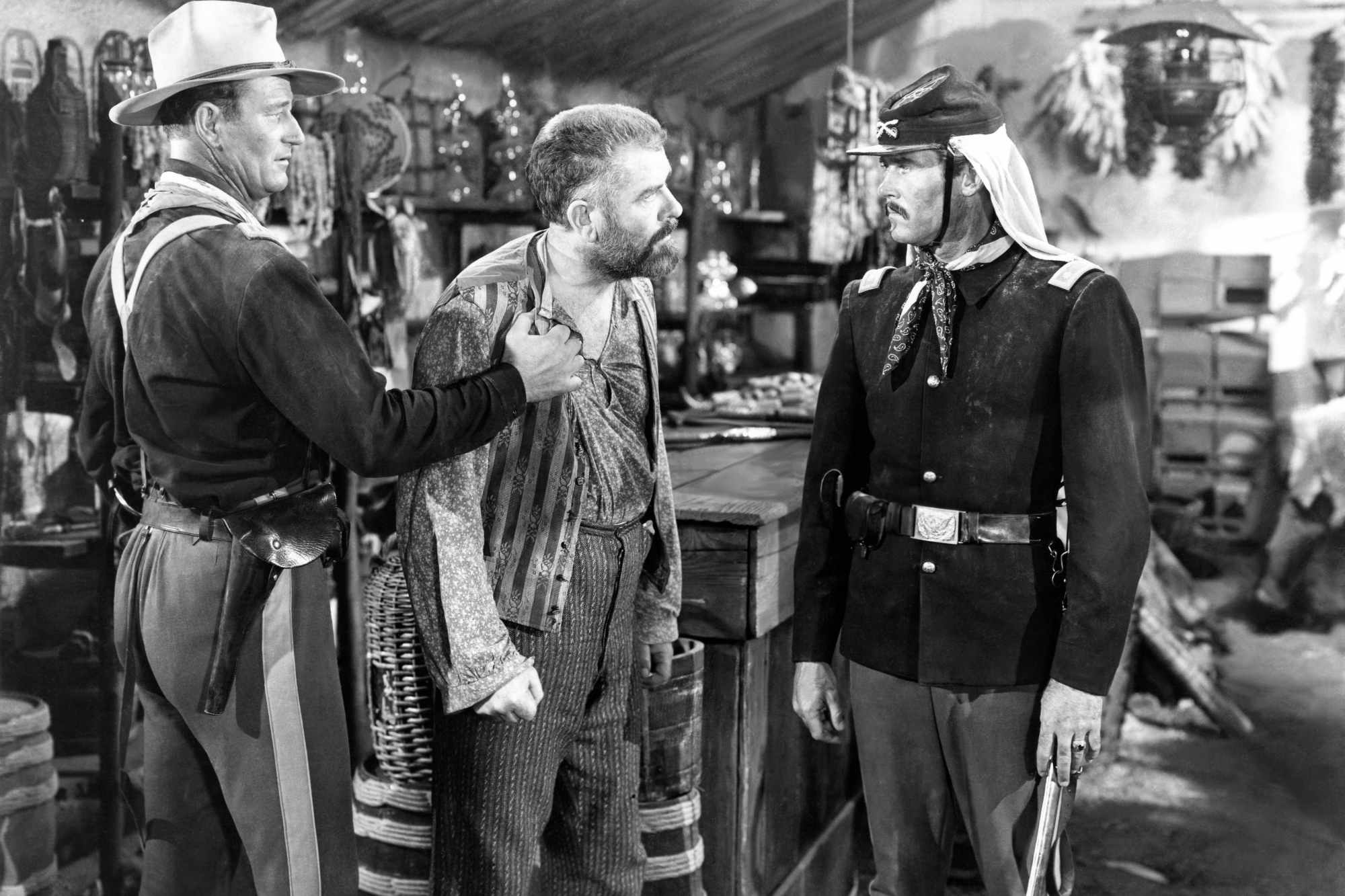 'Fort Apache' John Wayne as Capt. Kirby York, Grant Withers as Silas Meacham, and Henry Fonda as Lt. Col. Owen Thursday. Withers and Fonda looking frustrated, while Wayne holds back Withers.