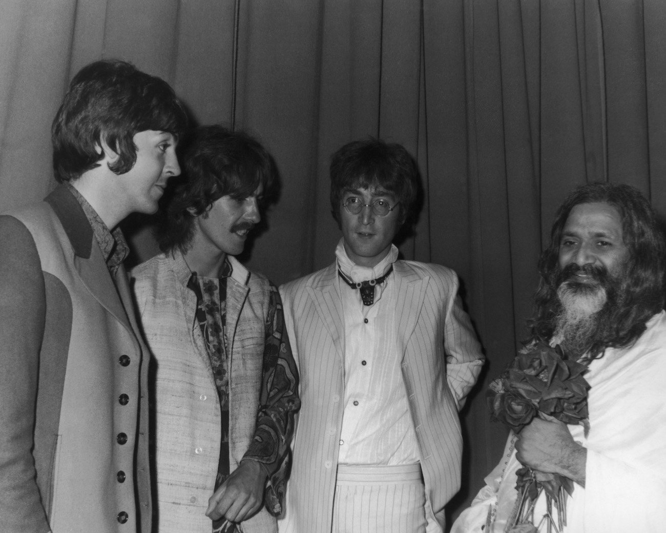 Paul McCartney, George Harrison, and John Lennon, speaking with the Maharishi Mahesh Yogi in 1967.
