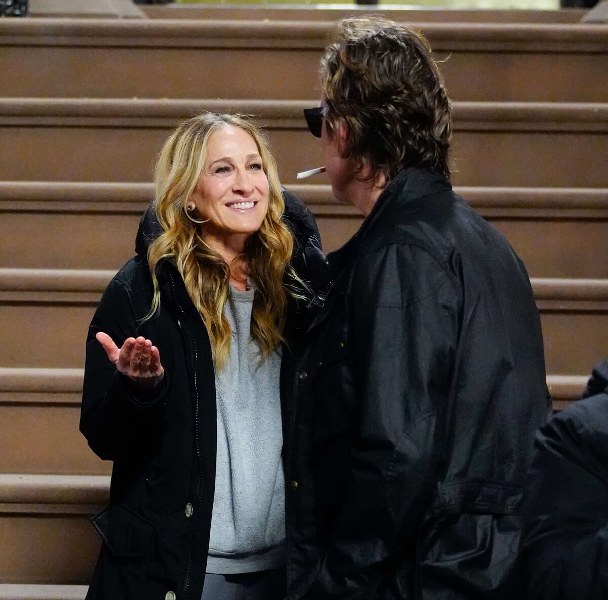 Carrie Bradshaw and Aidan Shaw stand outside of Carrie's brownstone in a scene for 'And Just Like That....'