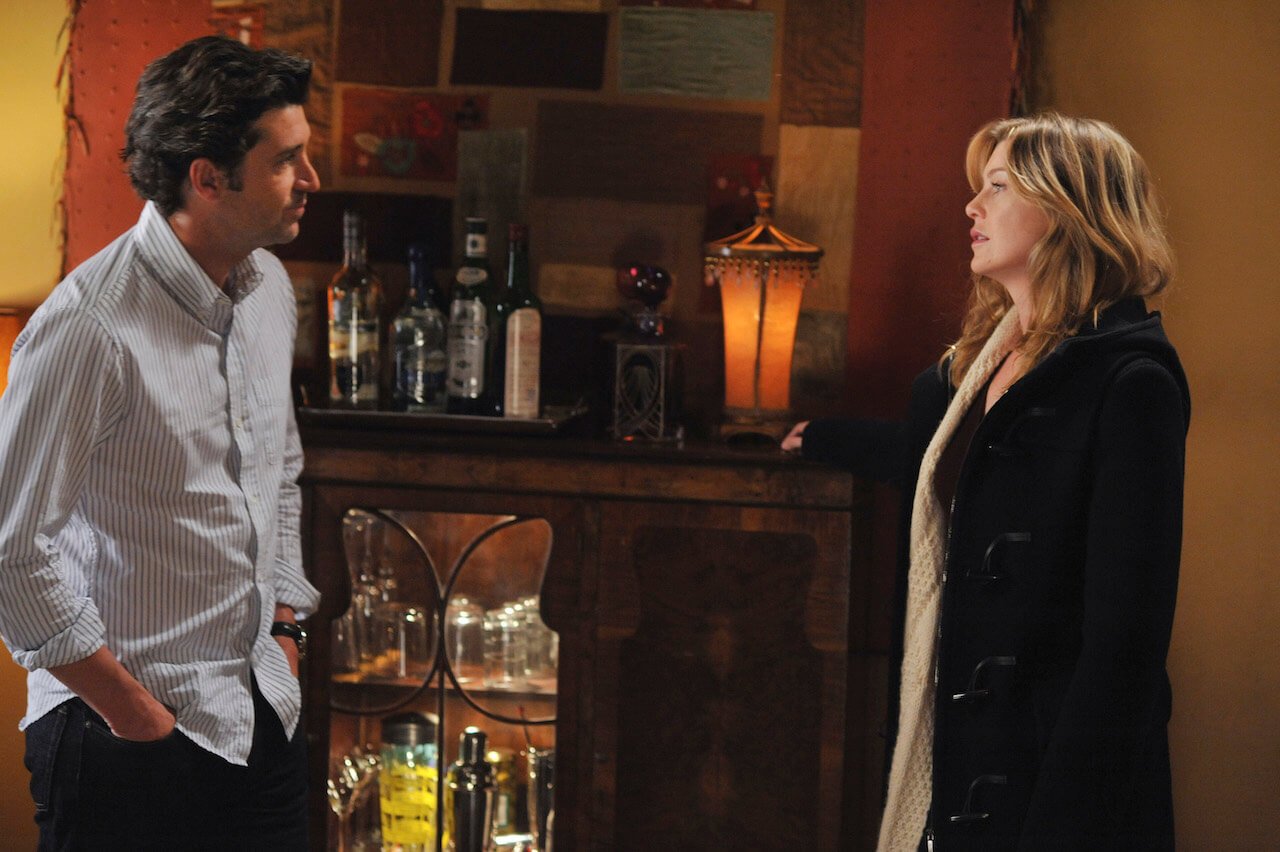 Patrick Dempsey as Derek Shepherd and Ellen Pompeo as Meredith Grey stand in Meredith's house looking at each other on 'Grey's Anatomy'.