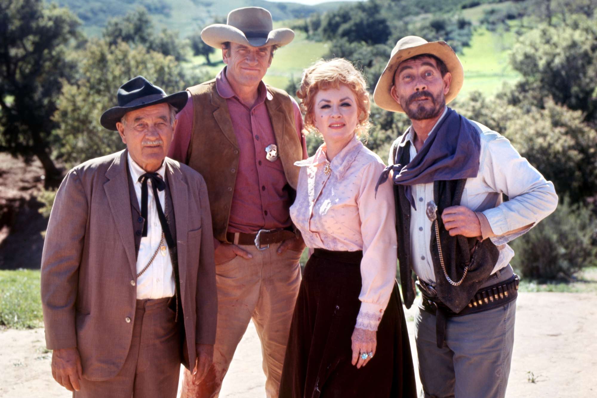 'Gunsmoke' shows Milburn Stone as Doc Adams, James Arness as Matt Dillon, Amanda Blake as Kitty Russell, and Ken Curtis as Festus Haggen standing next to each other wearing Western costumes