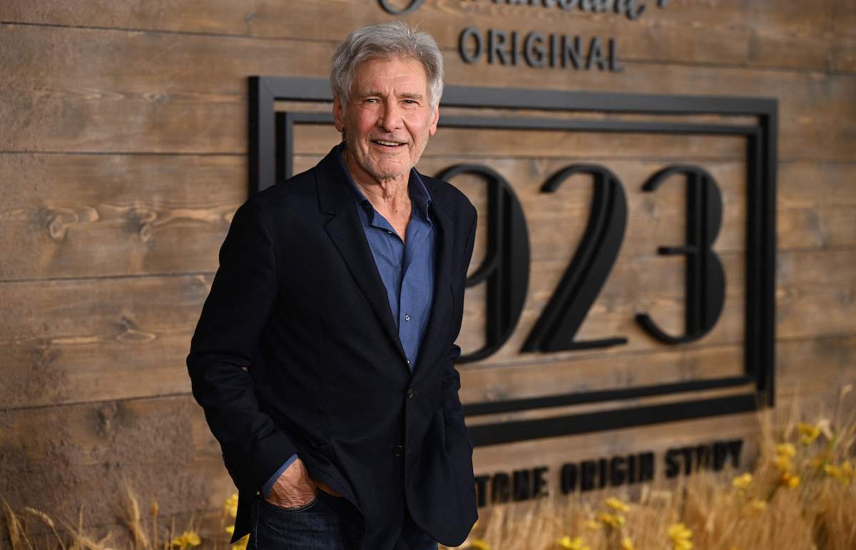 Harrison Ford stands in front of the "1923" logo