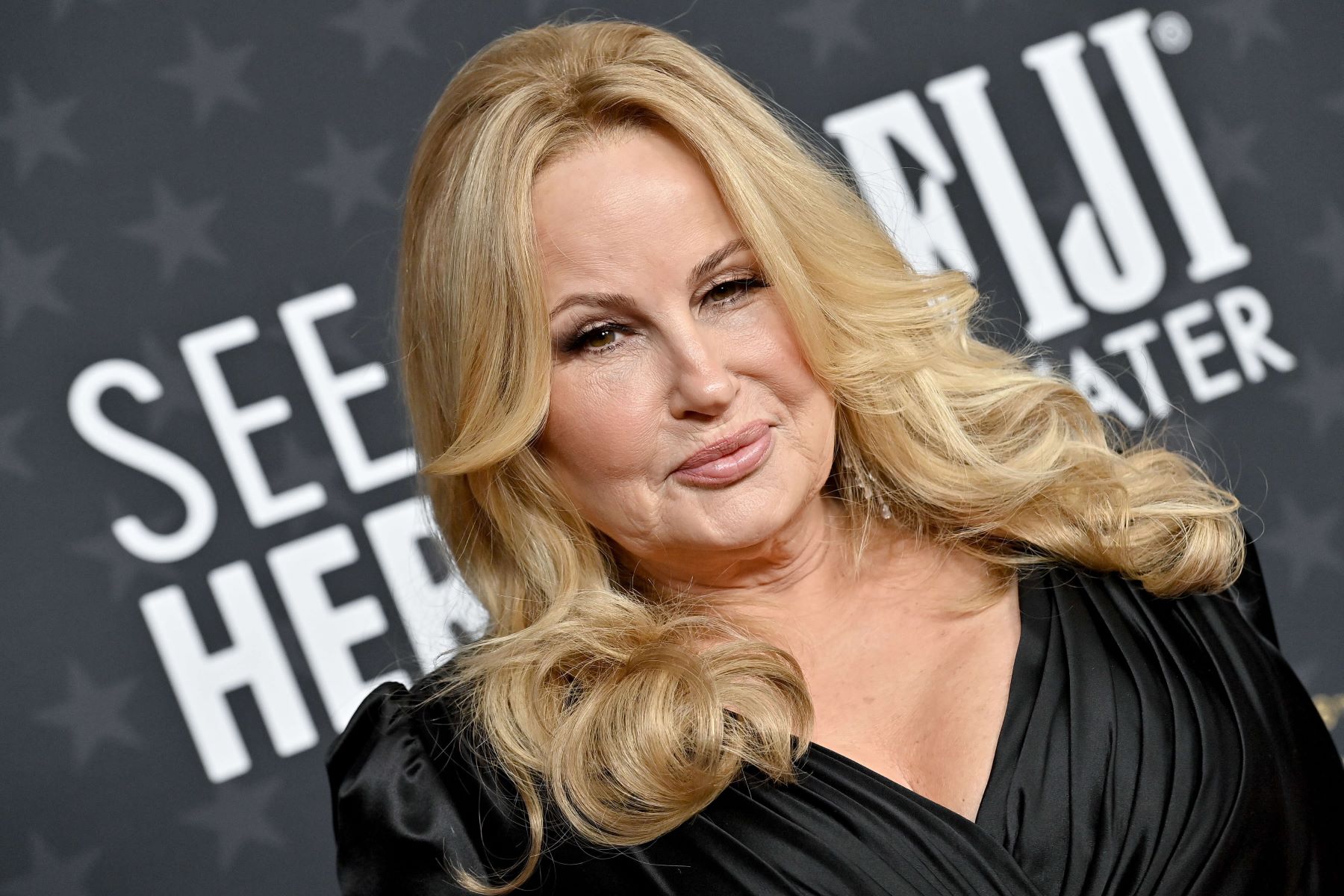 Jennifer Coolidge, who the 'How I Met Your Father' cast wants to see on their show, wears a black long-sleeved dress.