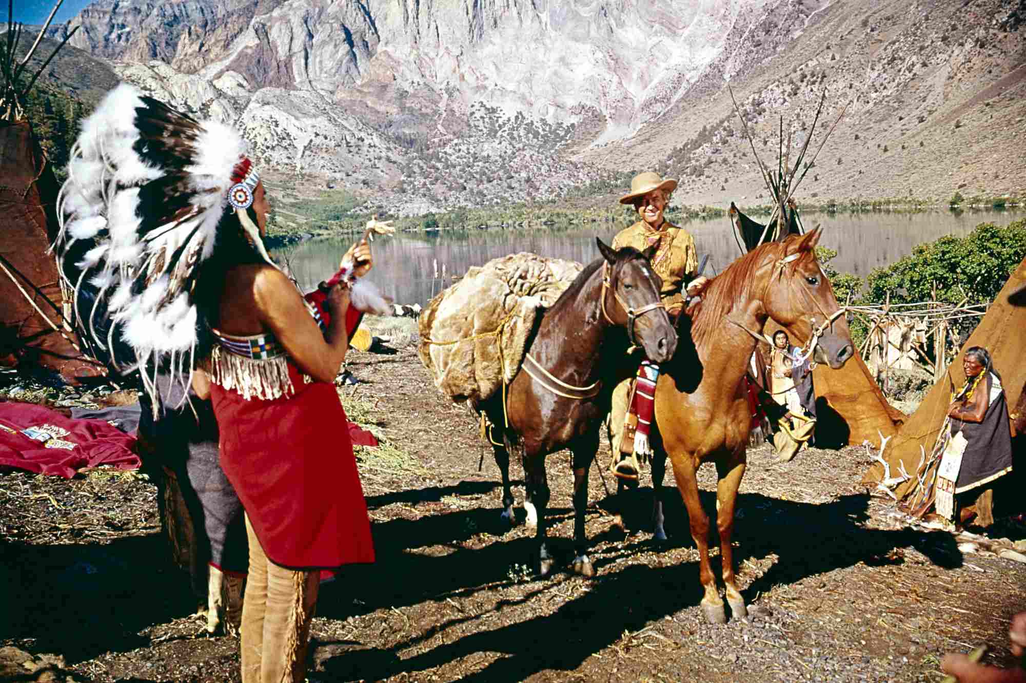 'How the West Was Won' James Stewart as Linus Rawlings on a horse standing in front of a Native American man in tribal dress.