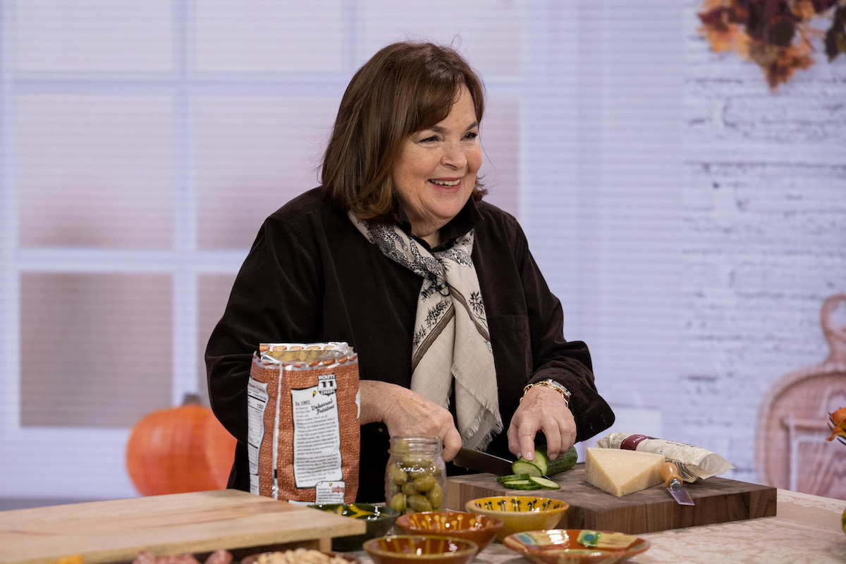 Ina Garten, who has Super Bowl Barefoot Contessa dishes, chops cucumbers and looks on