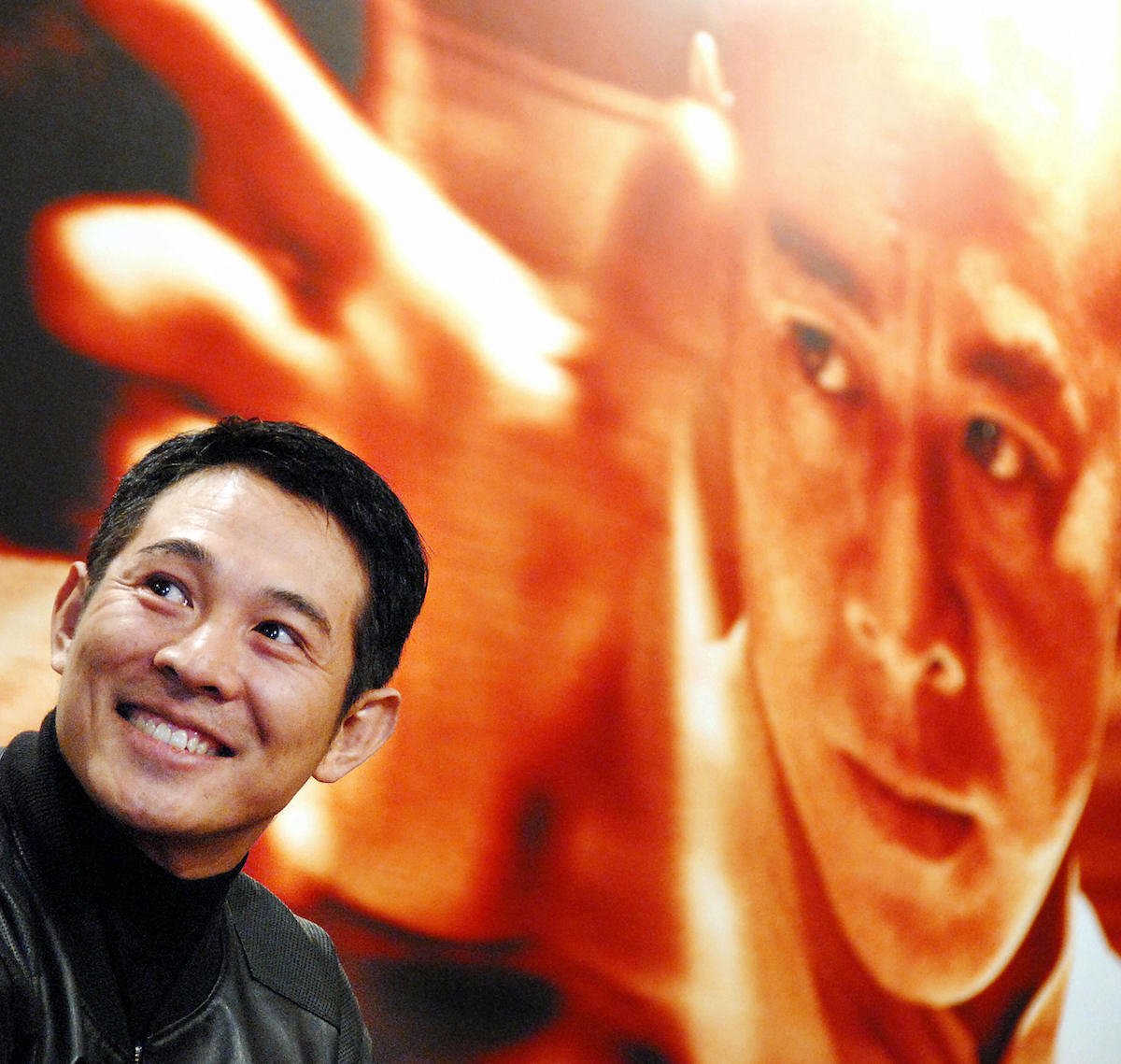International martial arts star Jet Li smiles against a backdrop of a poster for Fearless in 2006