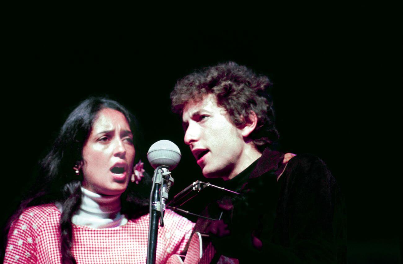 Joan Baez and Bob Dylan sing into the same microphone.