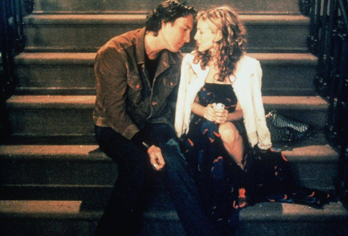 John Corbett and Sarah Jessica Parker sitting on a staircase for a scene in 'Sex and the City'