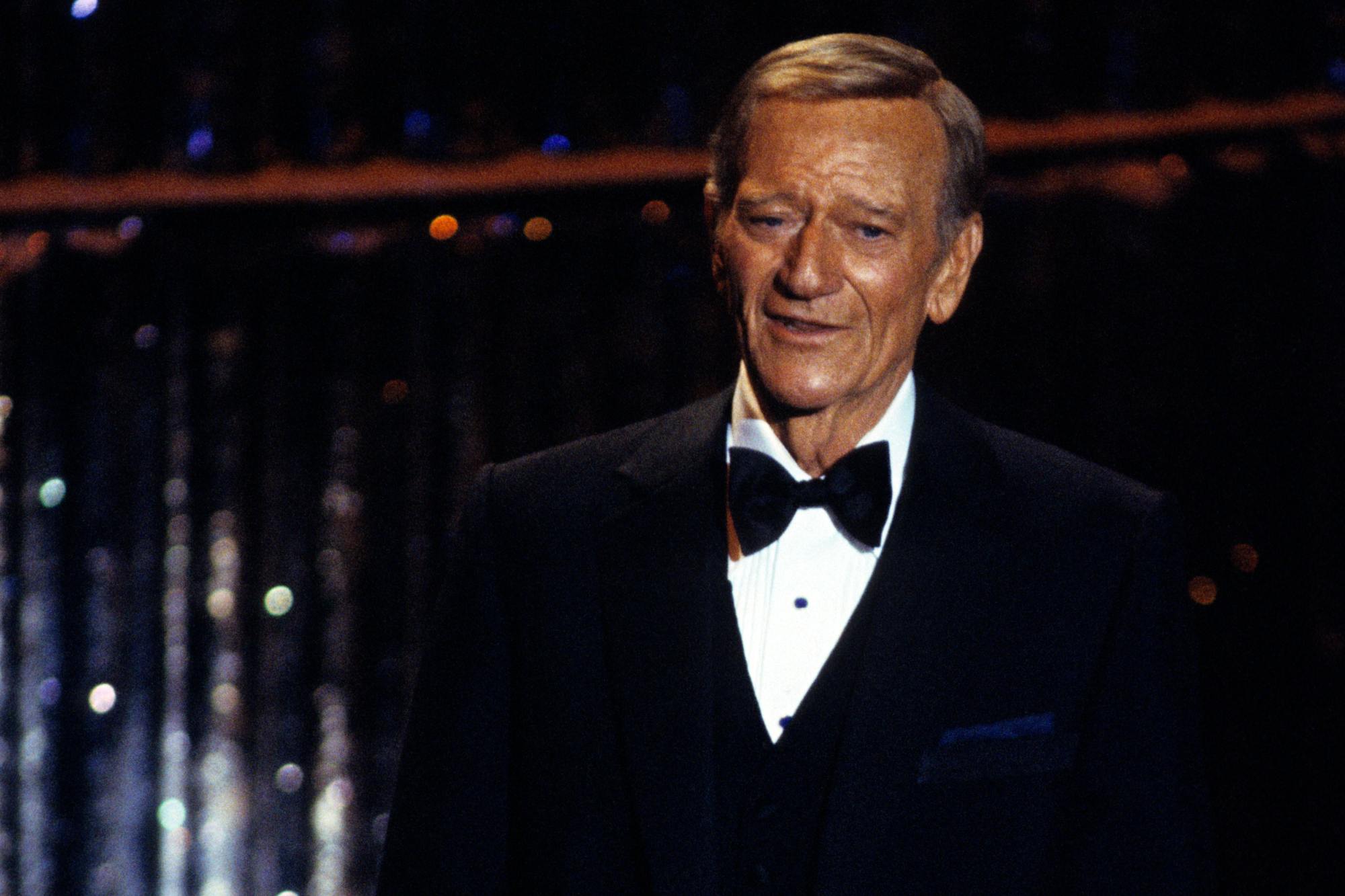 John Wayne at the 1979 Oscars, where he got a hug from Sammy Davis Jr. He's wearing a tux