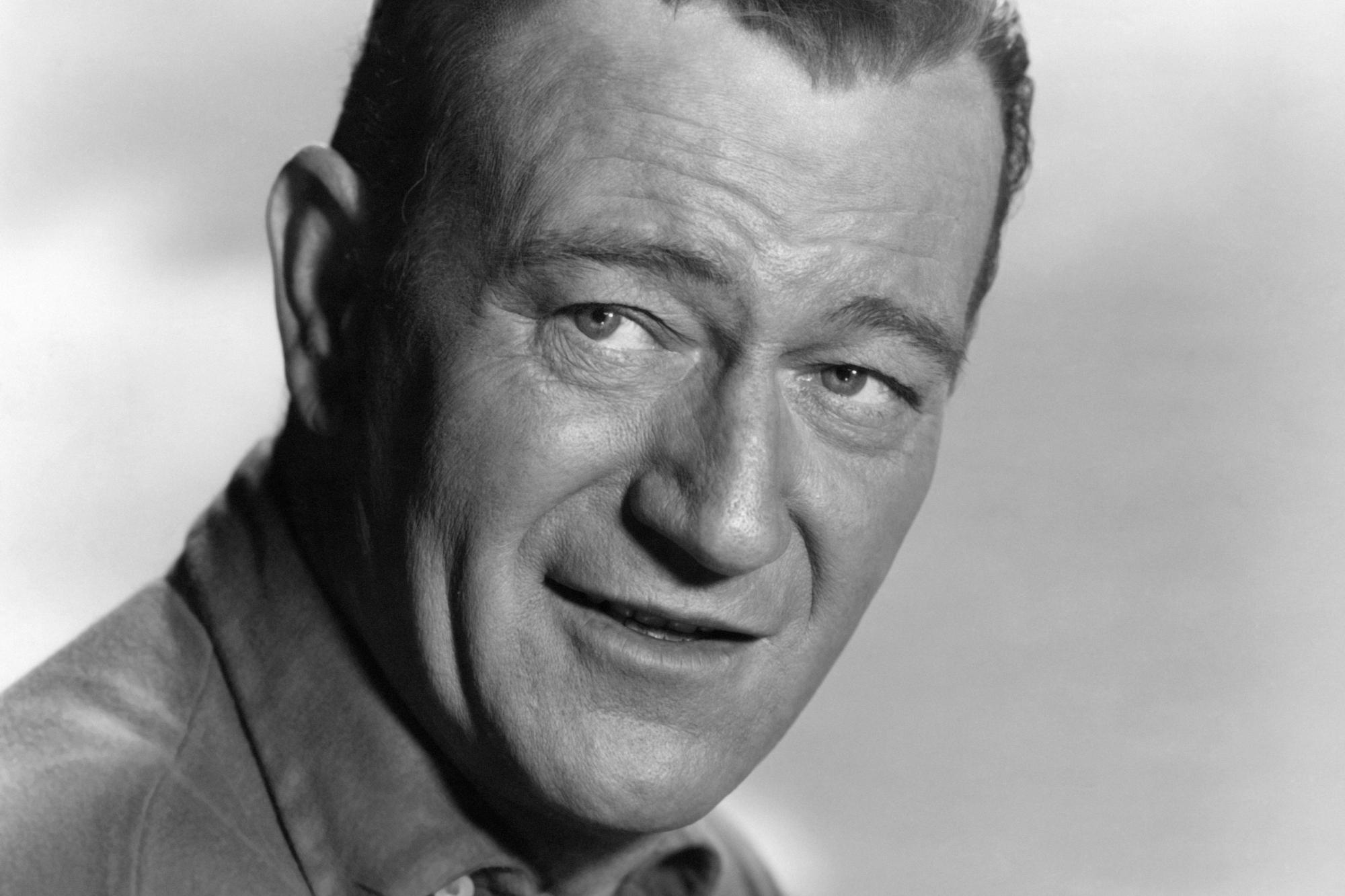 John Wayne, who didn't like 'The Wild Bunch.' He's smiling in a black-and-white portrait.