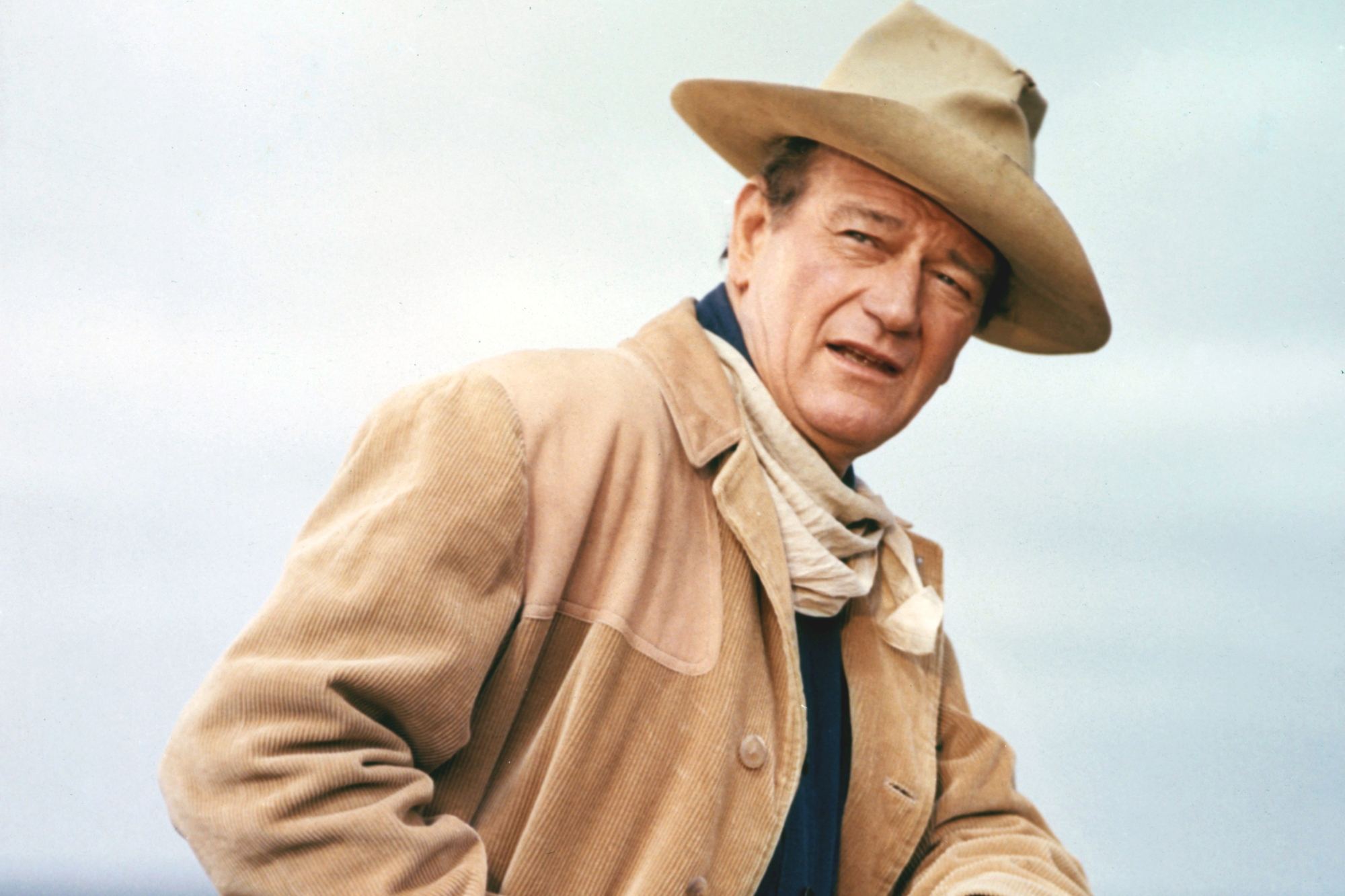 John Wayne, who met former Japanese Emperor Hirohito. He's wearing a cowboy hat and costume, looking at the camera