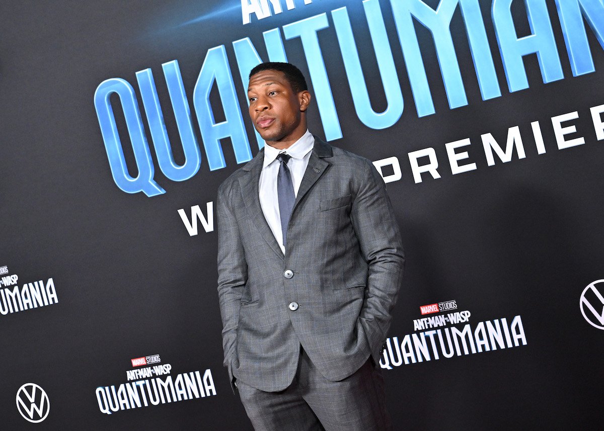 Jonathan Majors poses in front of an “Ant-Man and The Wasp: Quantumania" backdrop.