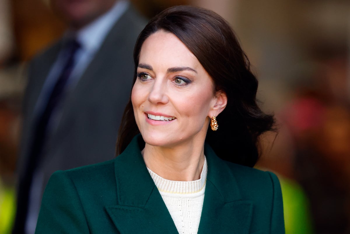 Kate Middleton, who appeared in a YouTube video, looks on wearing a green coat