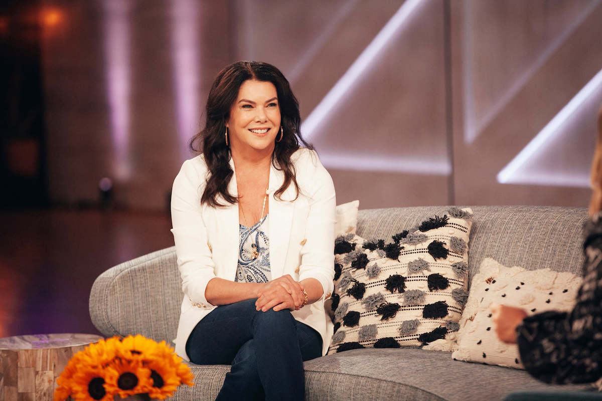 Lauren Graham smiling, sitting on a couch