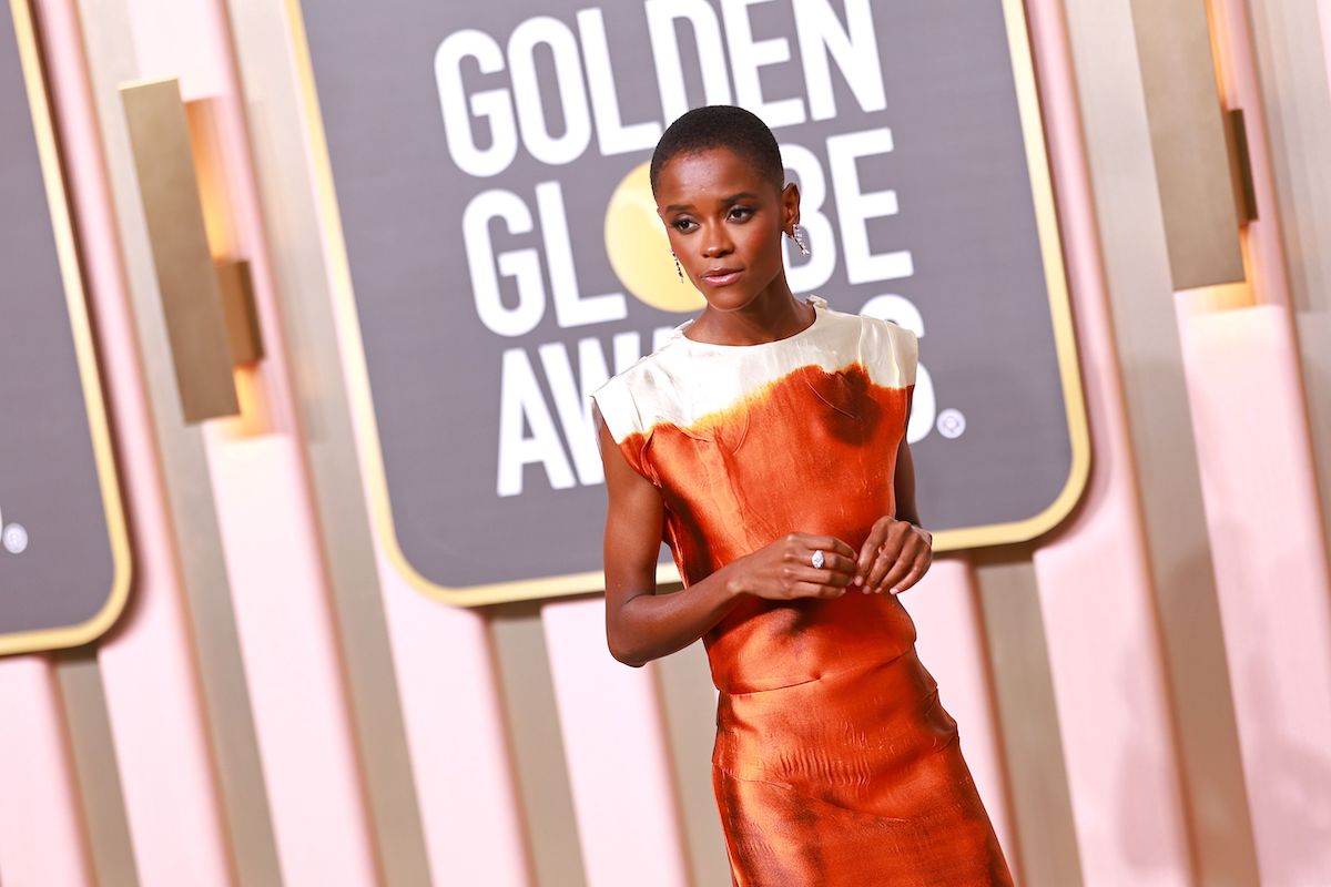 Letitia Wright attends the 80th Annual Golden Globe Awards in an orange dress