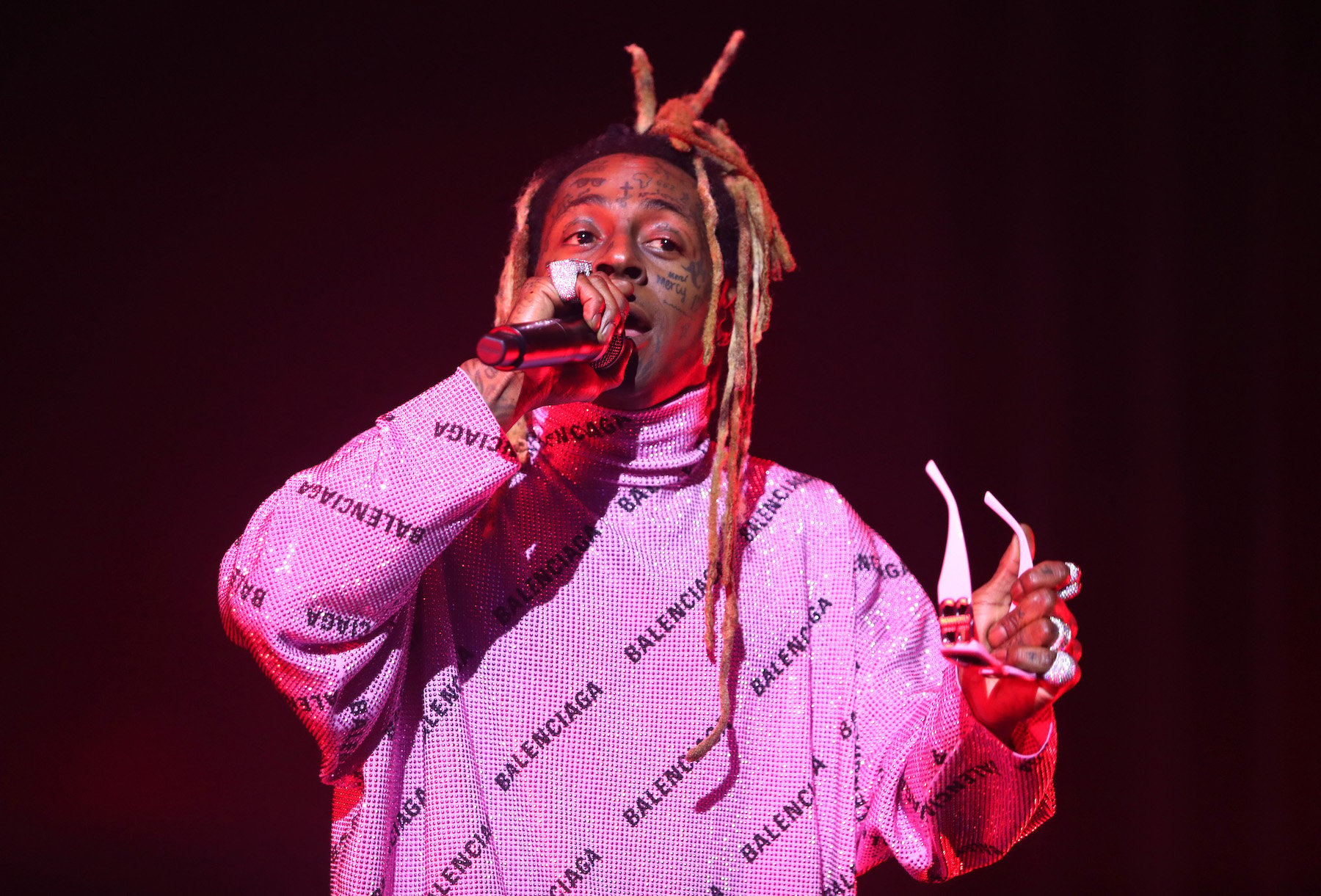 Lil Wayne, who once received a presidential pardon, on stage wearing a pink sweater