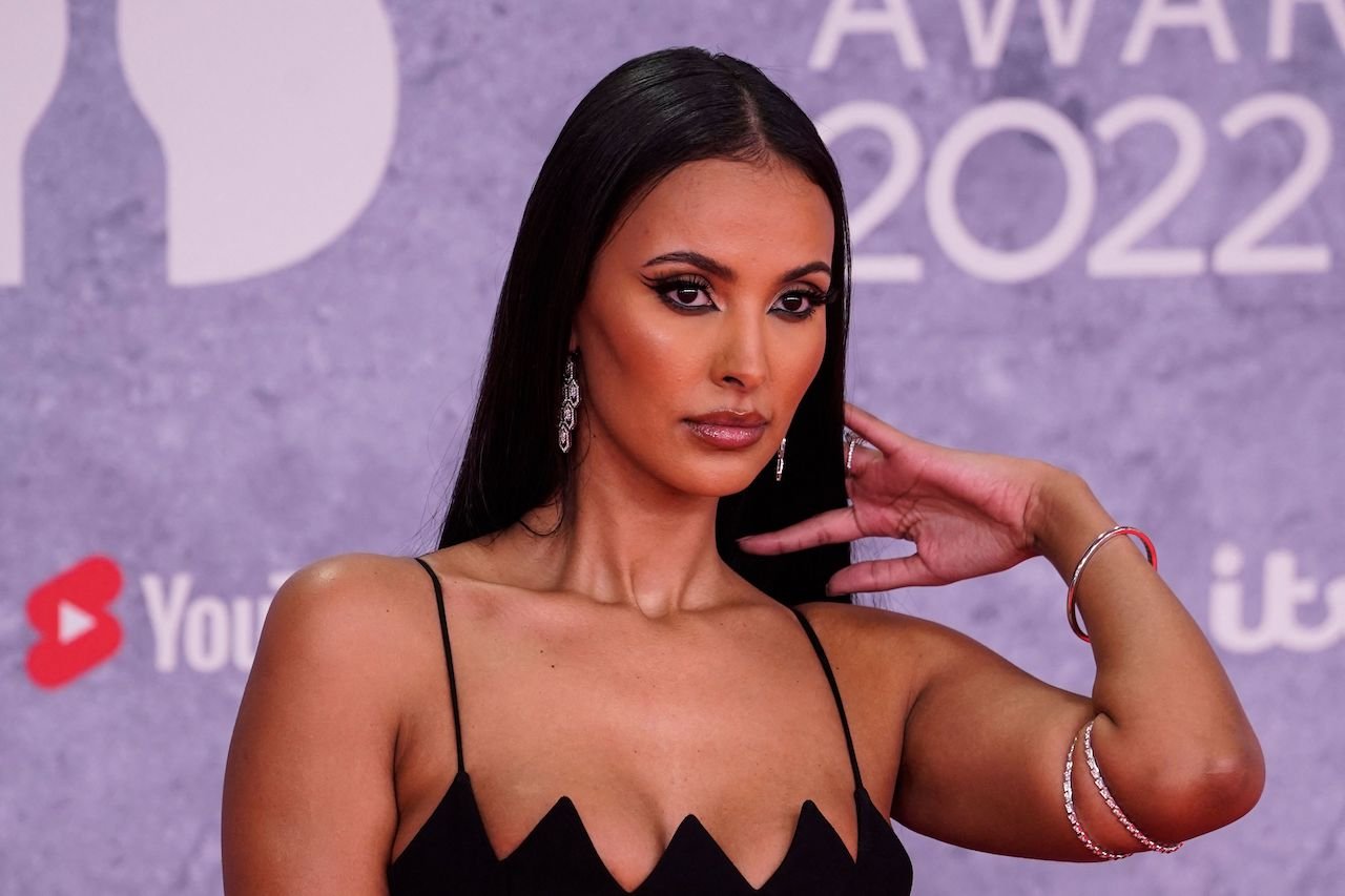 Maya Jama host of 'Love Island' poses on the red carpet in a black dress.