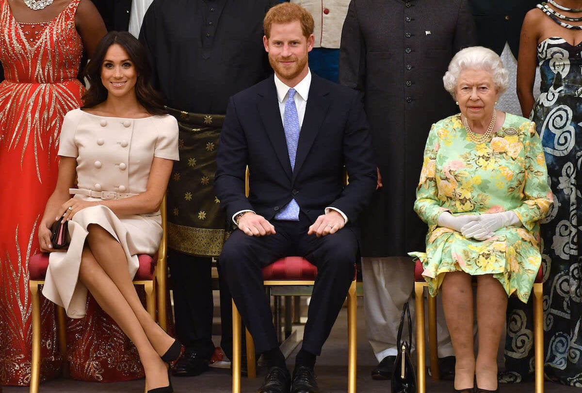 Meghan Markle, who gifted Prince Harry a Queen Elizabeth Christmas ornament, sits next to Prince Harry and Queen Elizabeth