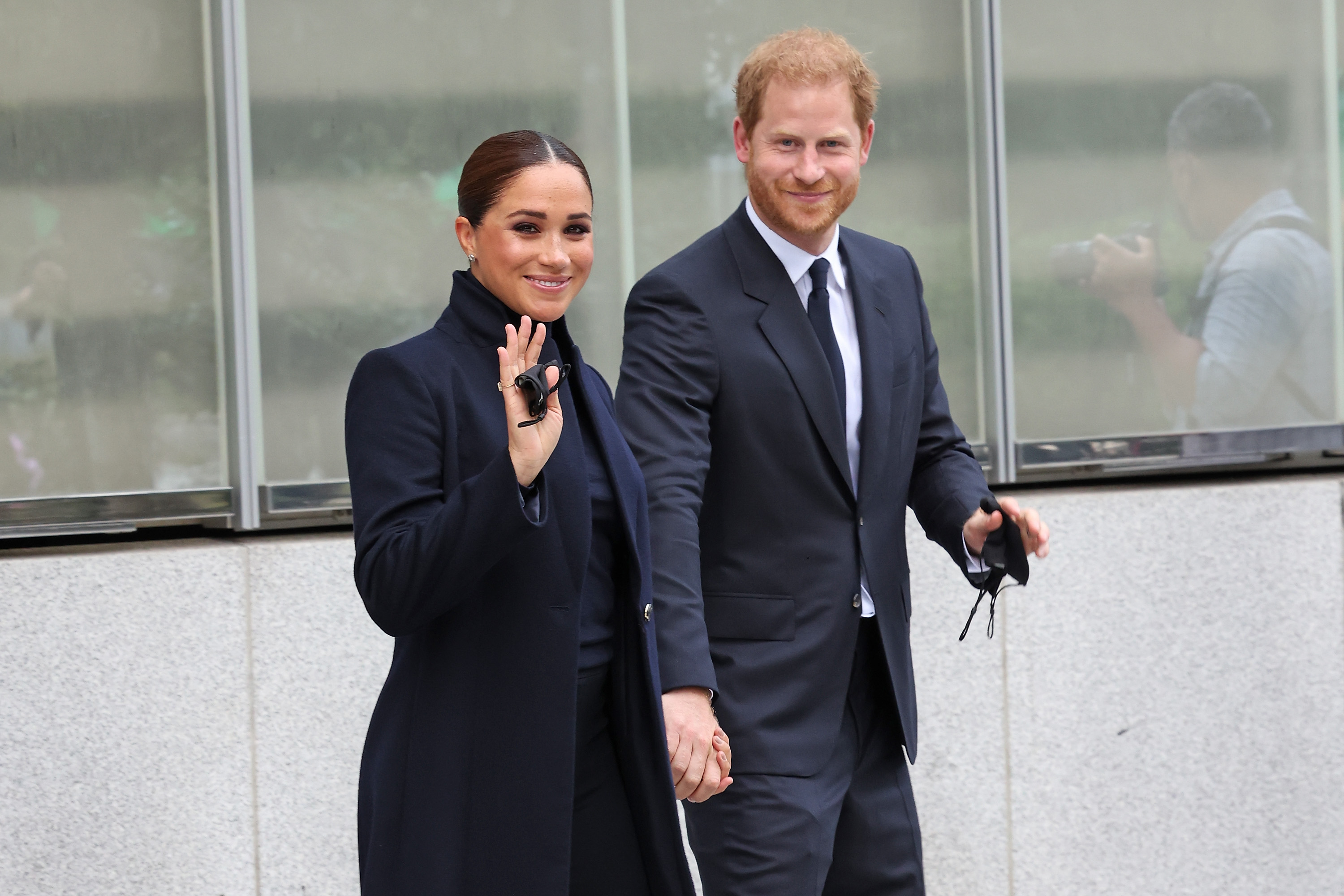 Meghan Markle and Prince Harry walk together and wave. 