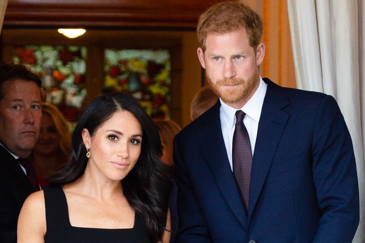 Meghan Markle and Prince Harry, who an expert says could adopt a last name, look on