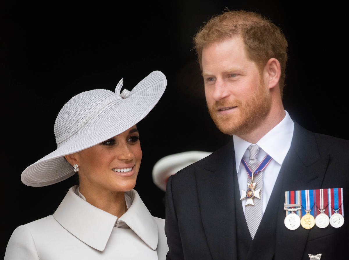 Meghan Markle and Prince Harry, who may repeat 2022 Platinum Jubilee weekend during King Charles' coronation, smile and look on