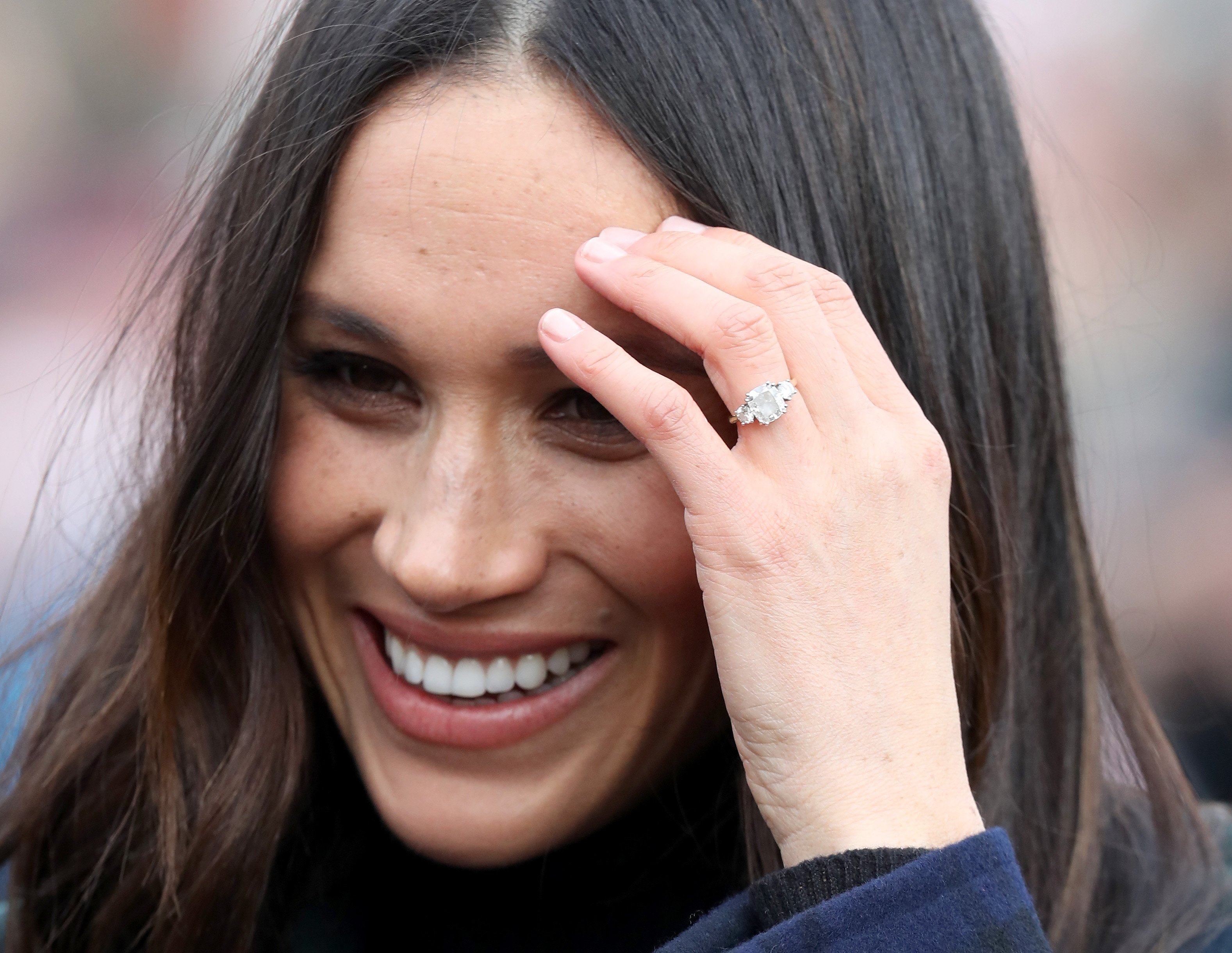 Meghan Markle's engagement ring can be seen as she talks to members of the public outside Edinburgh Castle