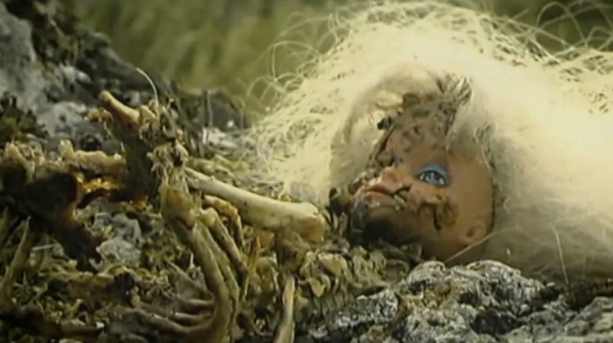 'Melancholie der Engel' doll head laying on a rock with the hair messed up