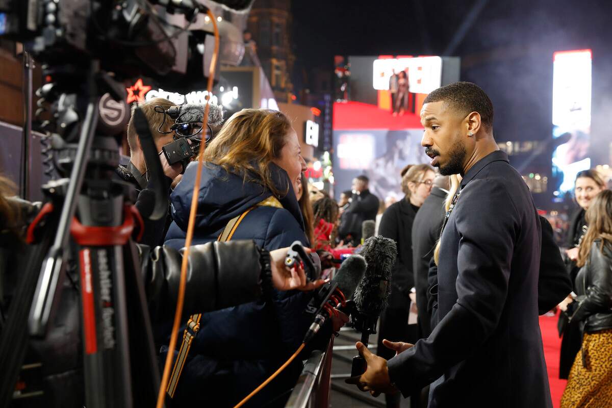 Michael B. Jordan speaks to a reporter at the Creed III premiere