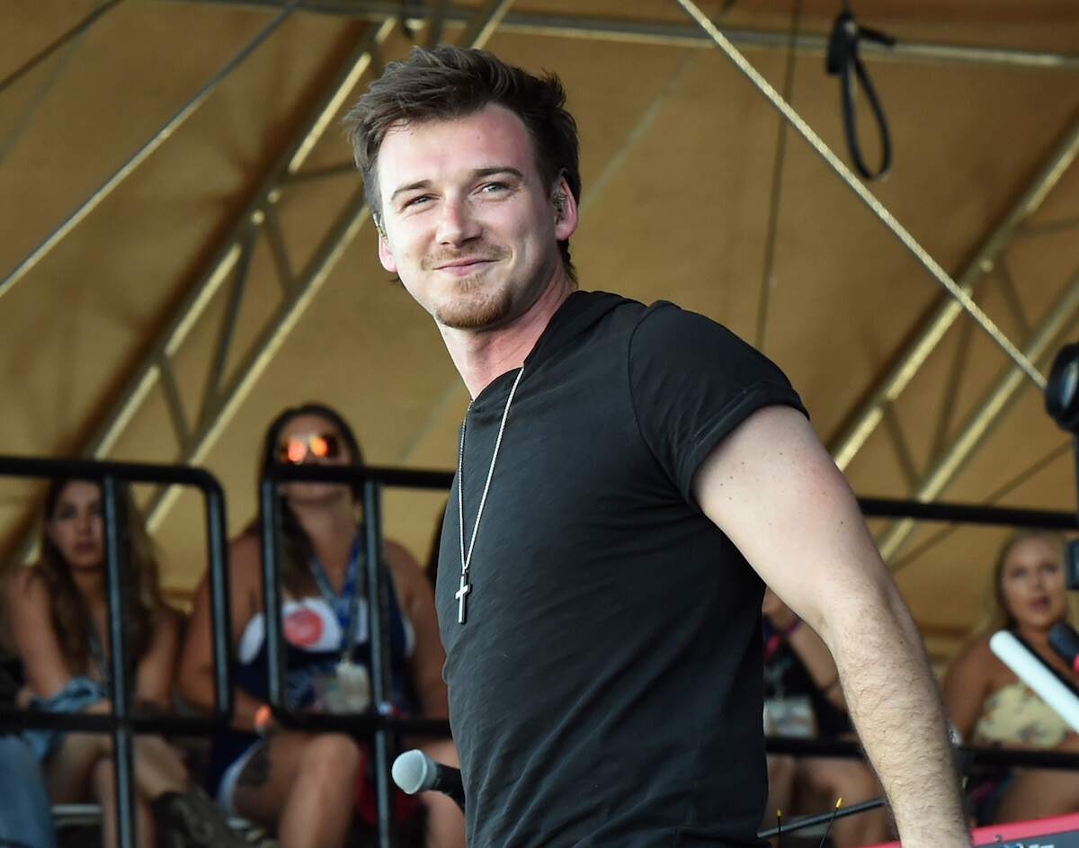 Wearing a black tee shirt and cross necklace, Morgan Wallen performs during Country Thunder Music Festival Arizona in 2018