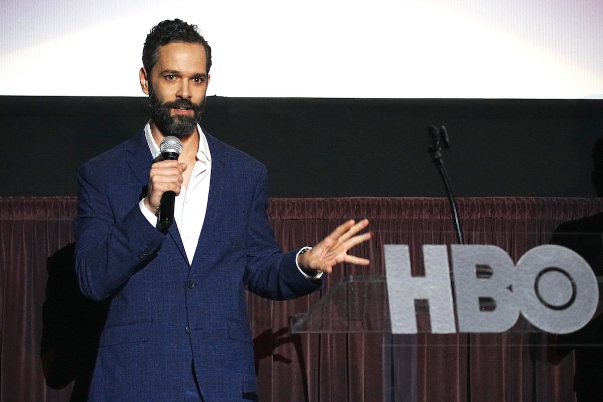 Neil Druckmann holds a microphone while speaking at an event for HBO.